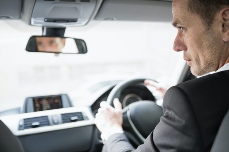 Businessman in the drivers seat in his car